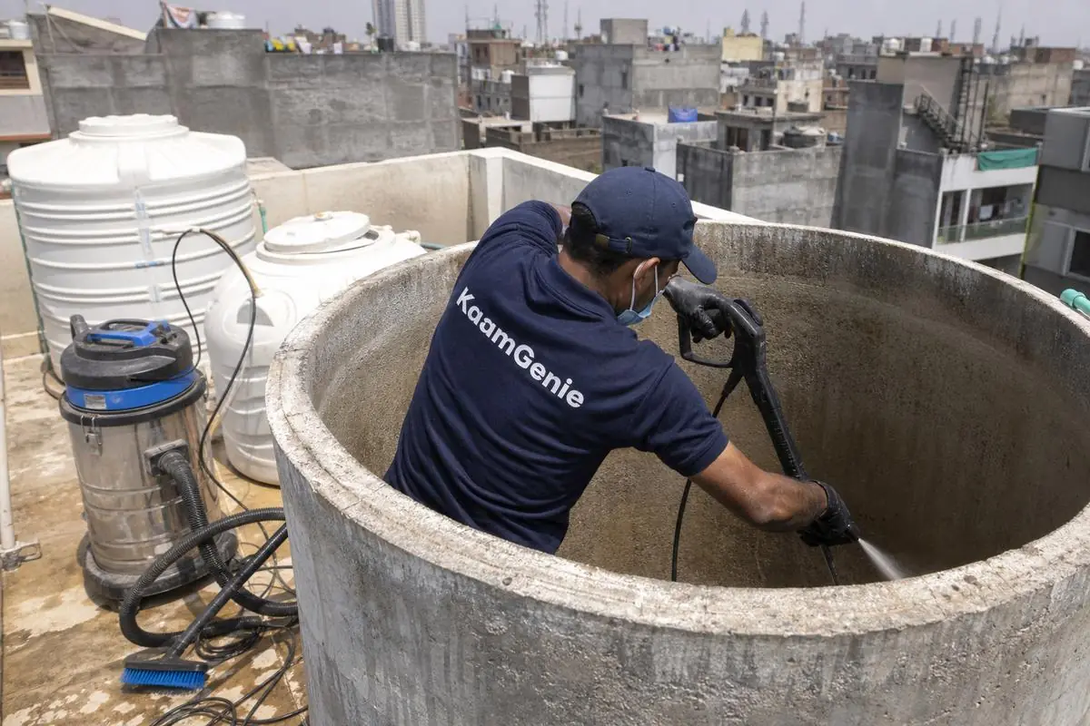 KaamGenie crew cleaning a overhead (rooftop) tank in Kishan Ganj, Delhi