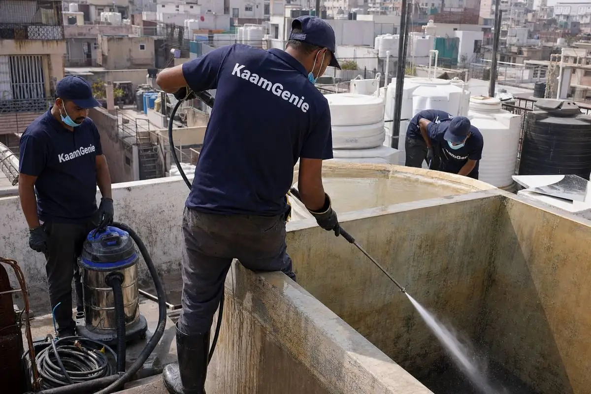KaamGenie crew cleaning a overhead (rooftop) tank in Madangir, Delhi