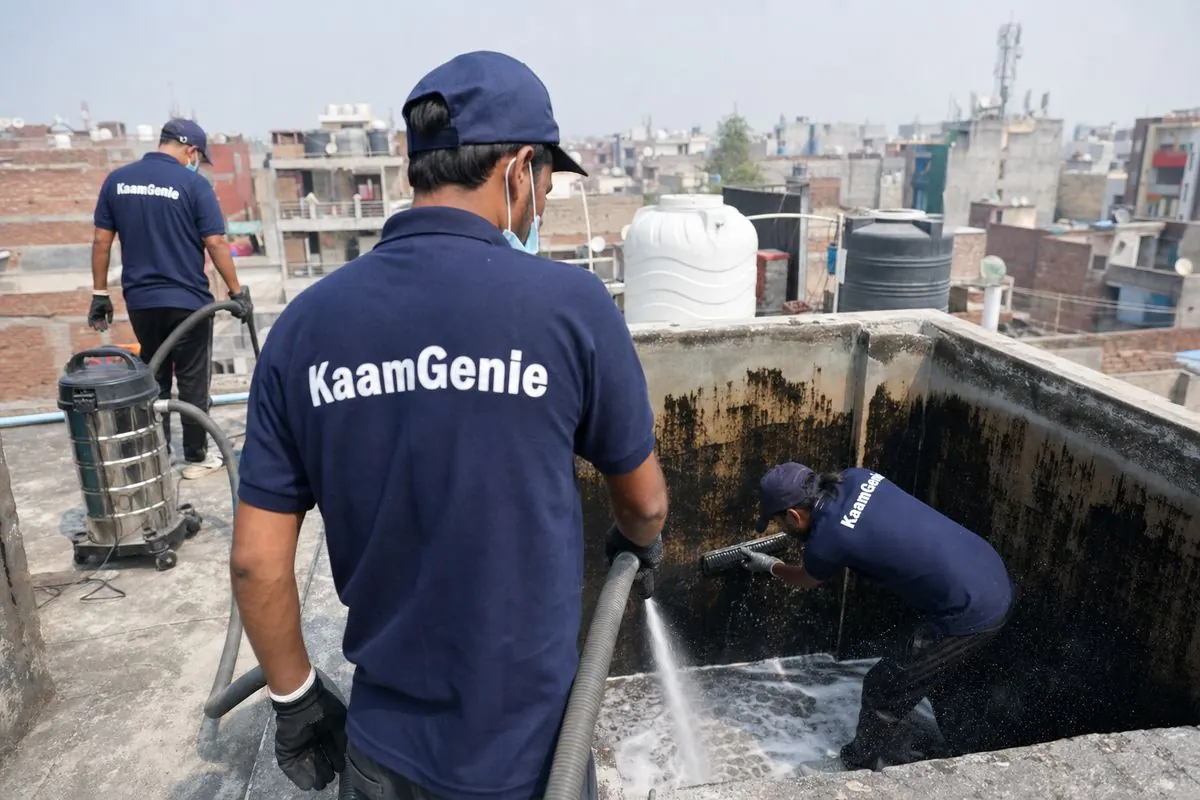 KaamGenie crew cleaning a overhead (rooftop) tank in Meethapur, Delhi