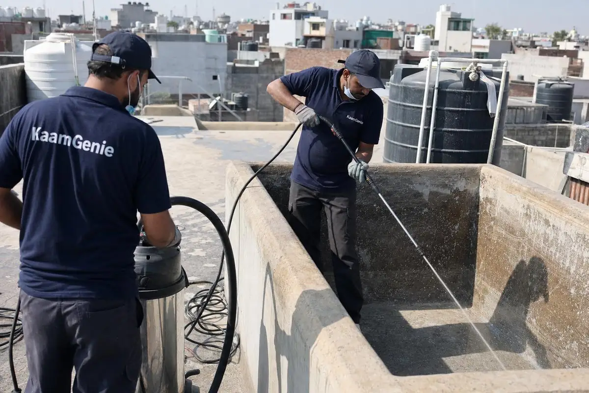 KaamGenie crew cleaning a overhead (rooftop) tank in Rangpuri, Delhi