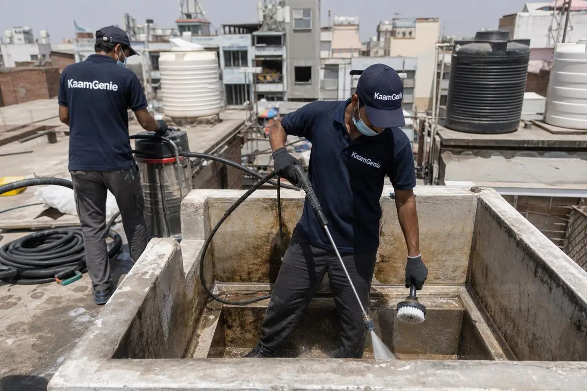 KaamGenie crew cleaning a overhead (rooftop) tank in Sadar Bazar, Delhi