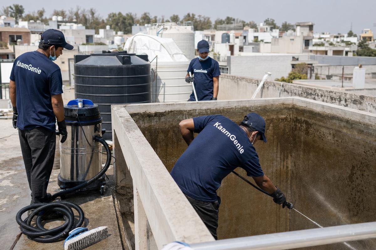 KaamGenie crew cleaning a overhead (rooftop) tank in Sainik Farms, Delhi