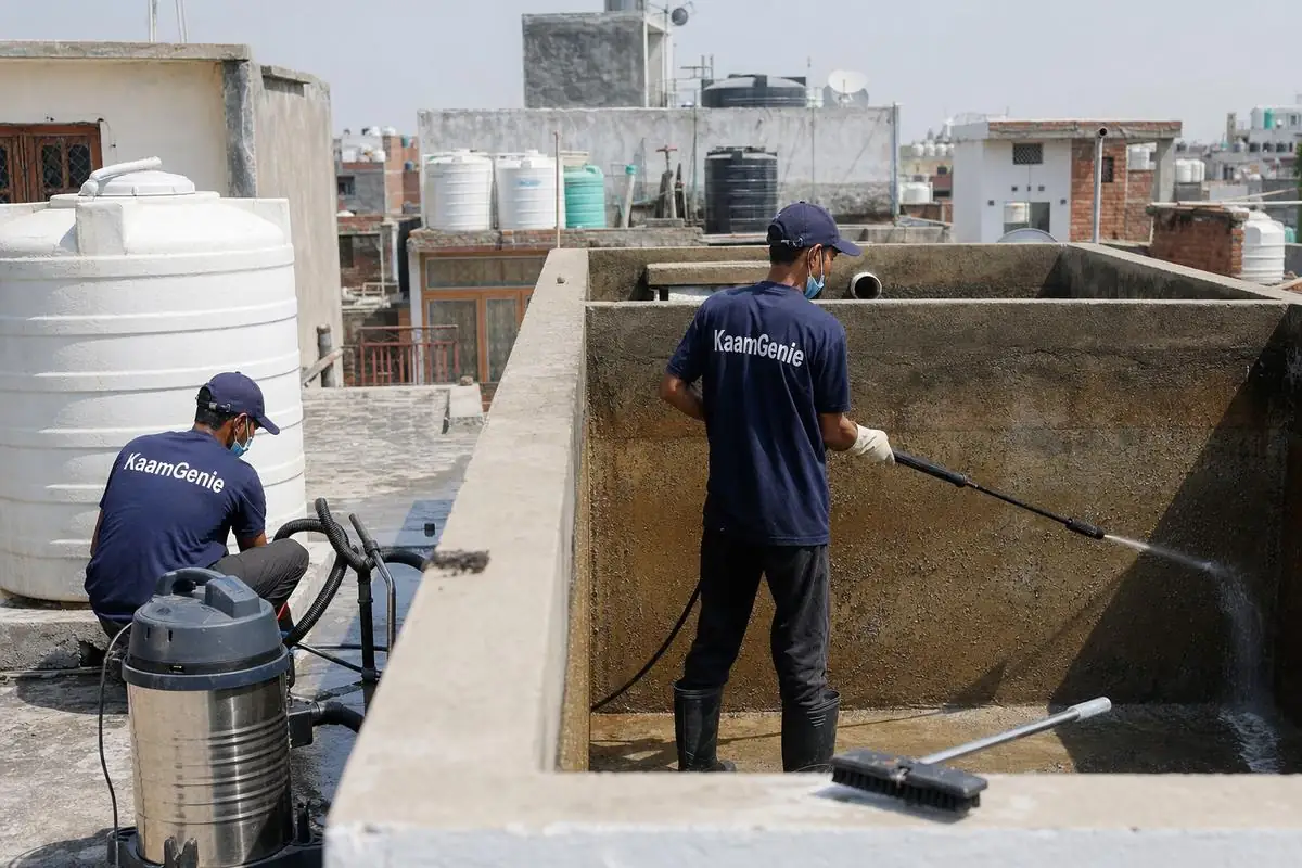KaamGenie crew cleaning a overhead (rooftop) tank in Sangam Vihar Extension, Delhi