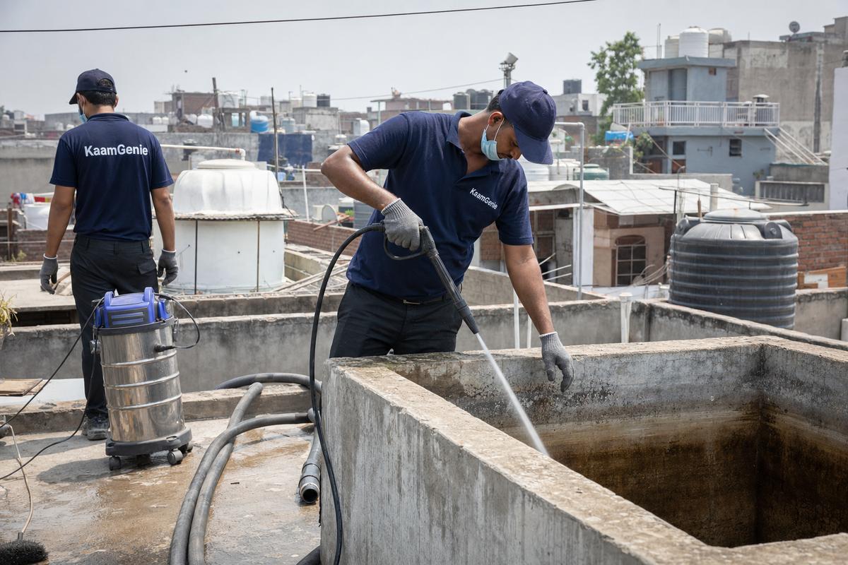 KaamGenie crew cleaning a overhead (rooftop) tank in Sangam Vihar, Delhi