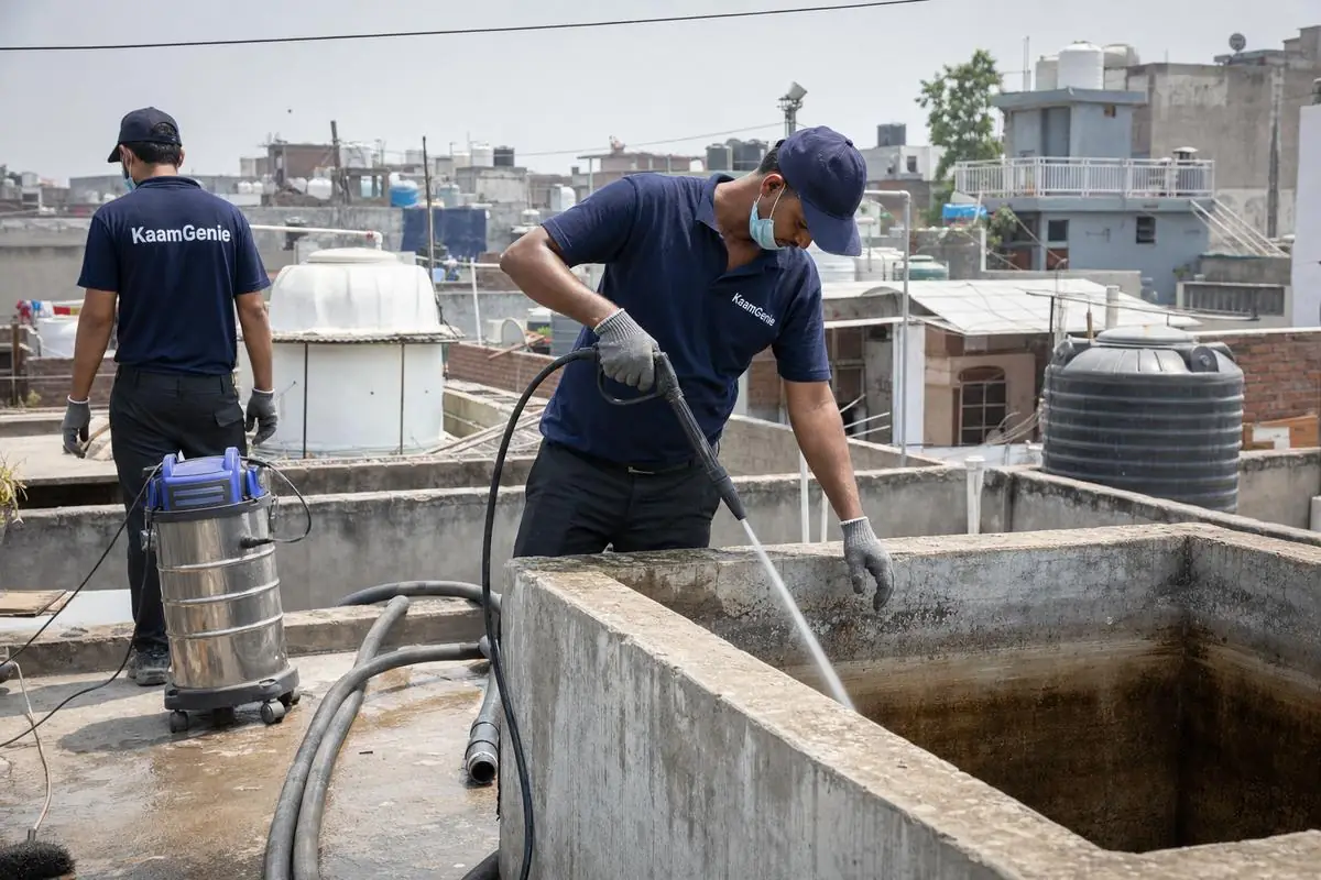 KaamGenie crew cleaning a overhead (rooftop) tank in Sangam Vihar, Delhi