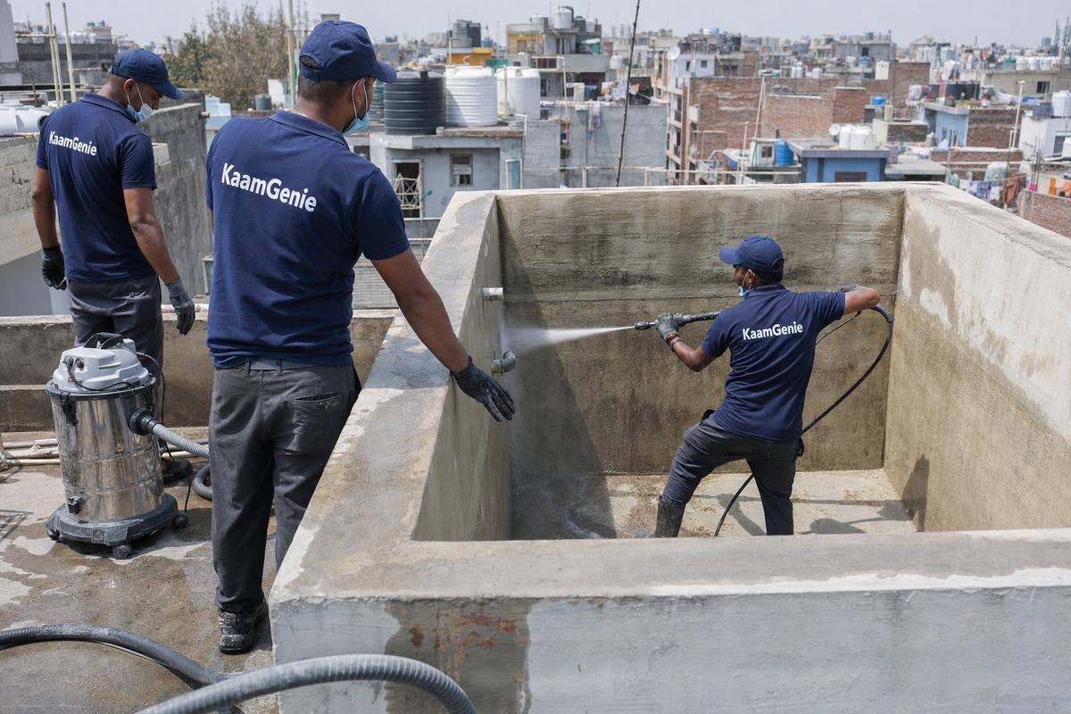 KaamGenie crew cleaning a overhead (rooftop) tank in Tehkhand, Delhi