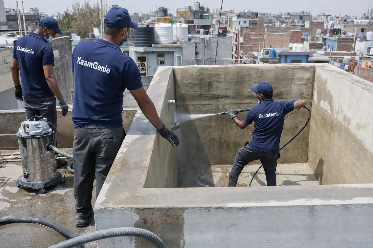 KaamGenie crew cleaning a overhead (rooftop) tank in Tehkhand, Delhi