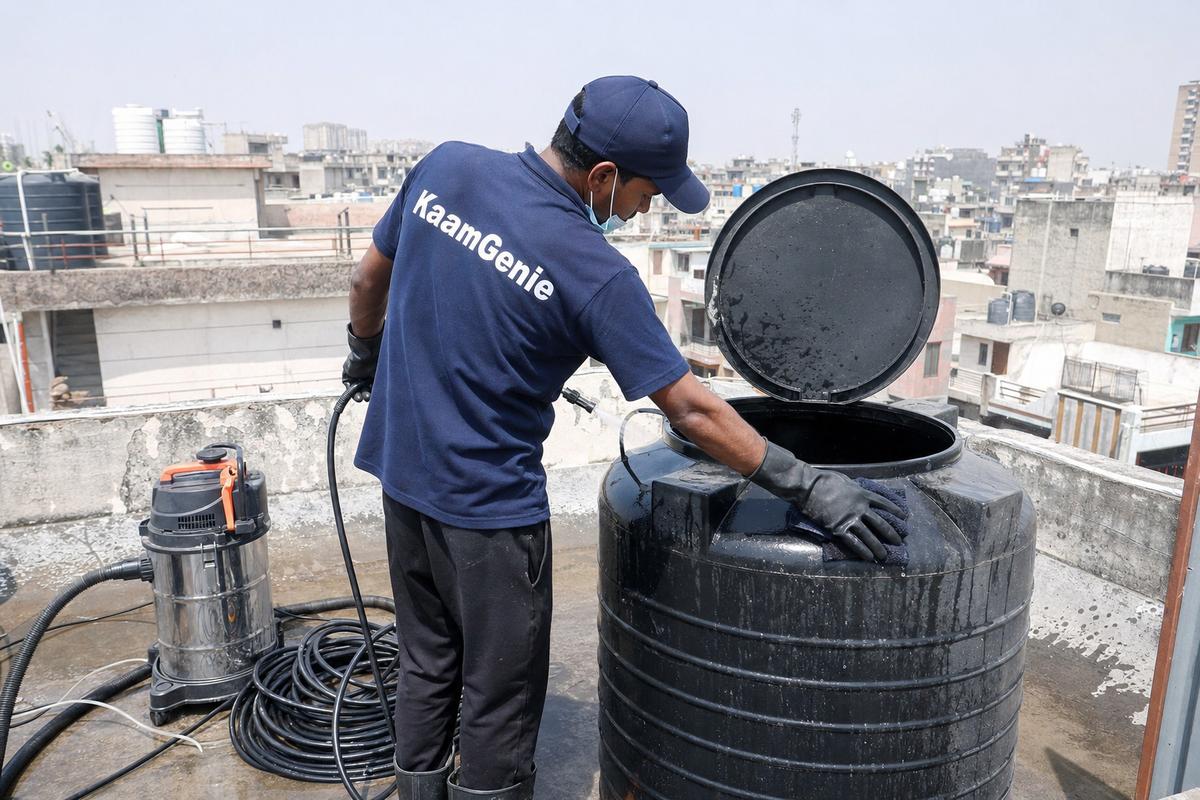 KaamGenie crew cleaning a Sintex / plastic tank in Dwarka Mor, Delhi