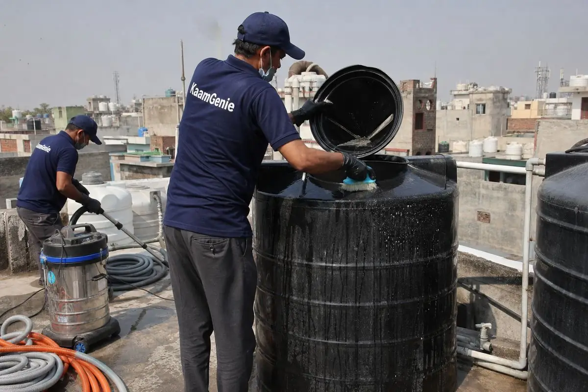 KaamGenie crew cleaning a Sintex / plastic tank in Gandhi Nagar Bazar, Delhi