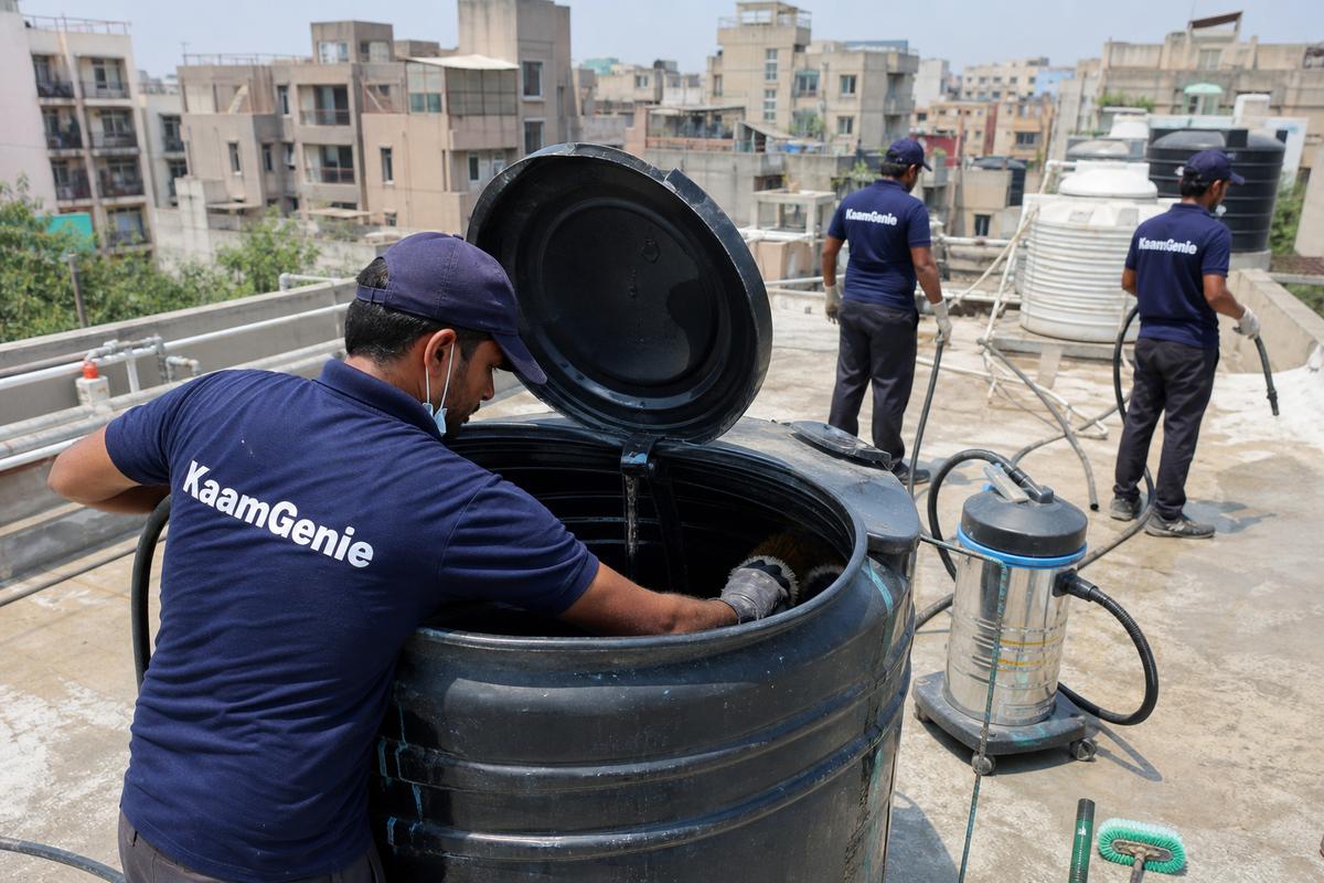 KaamGenie crew cleaning a Sintex / plastic tank in IP Extension, Delhi