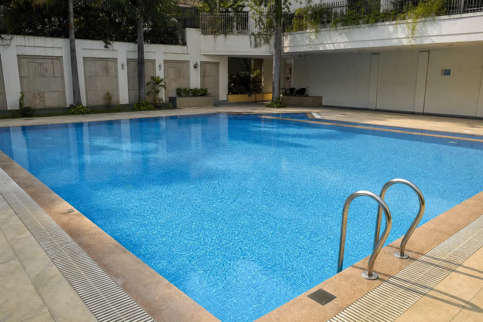 Price guide chart beside a clean swimming pool cleaned by KaamGenie in Delhi NCR
