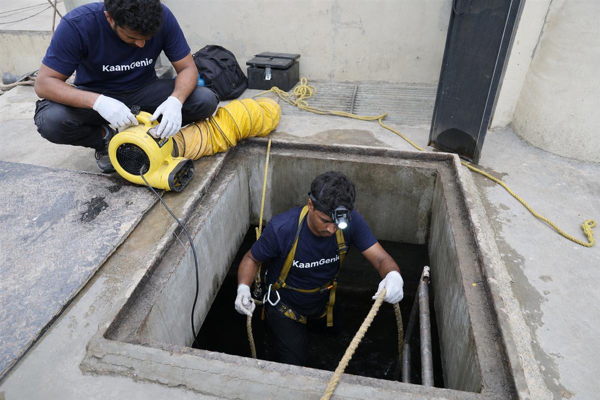 Thick iron-stained sludge and grit settled on the floor of a Noida underground concrete water reservoir before desludging