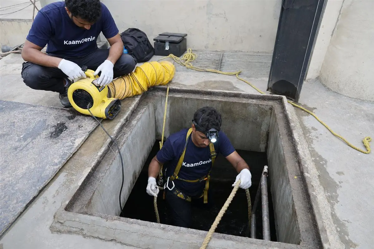 Thick iron-stained sludge and grit settled on the floor of a Noida underground concrete water reservoir before desludging