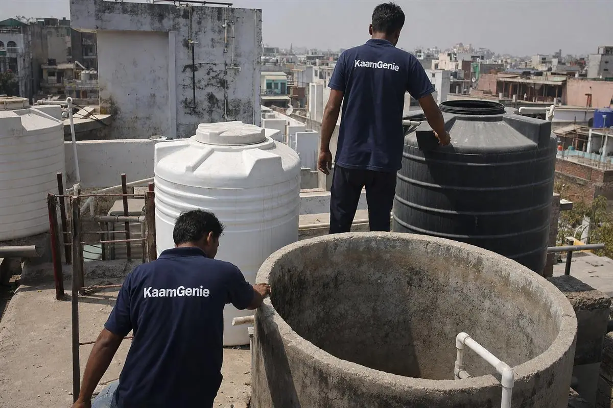 Several different-sized plastic and concrete water tanks of varying capacity on a Delhi rooftop terrace