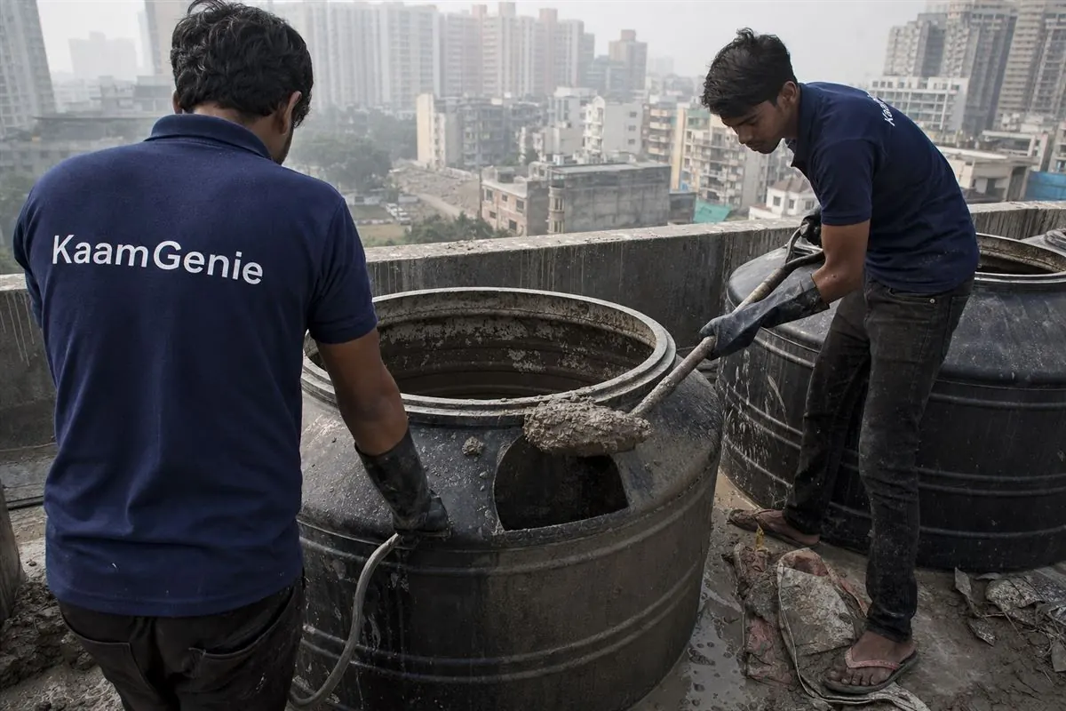 Cement slurry and construction debris being scooped from the bottom of a new water tank in a Noida flat before move-in