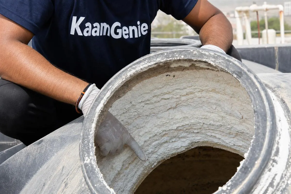 KaamGenie crew cleaning a large underground water reservoir in a Gurgaon condominium with safety harness and submersible pump