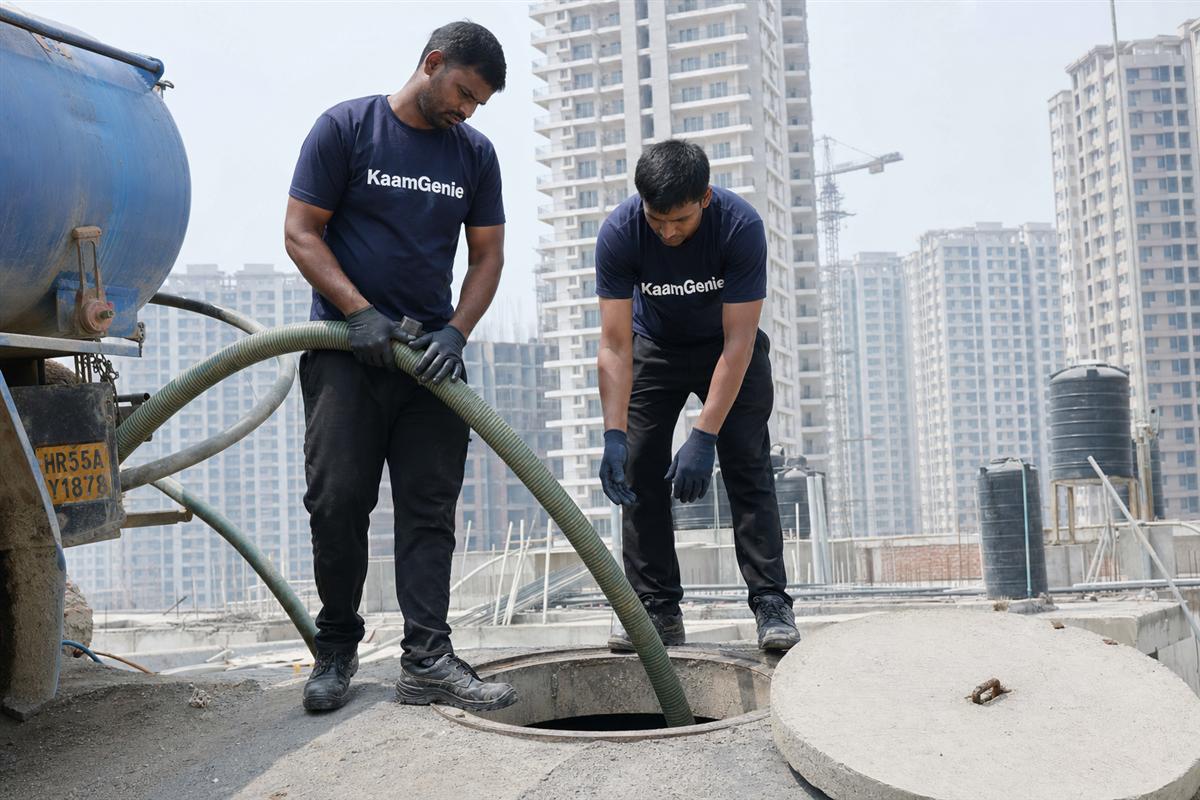 KaamGenie crew cleaning a rooftop society water tank in a newly handed-over high-rise tower on Dwarka Expressway, New Gurgaon, with other towers in the background