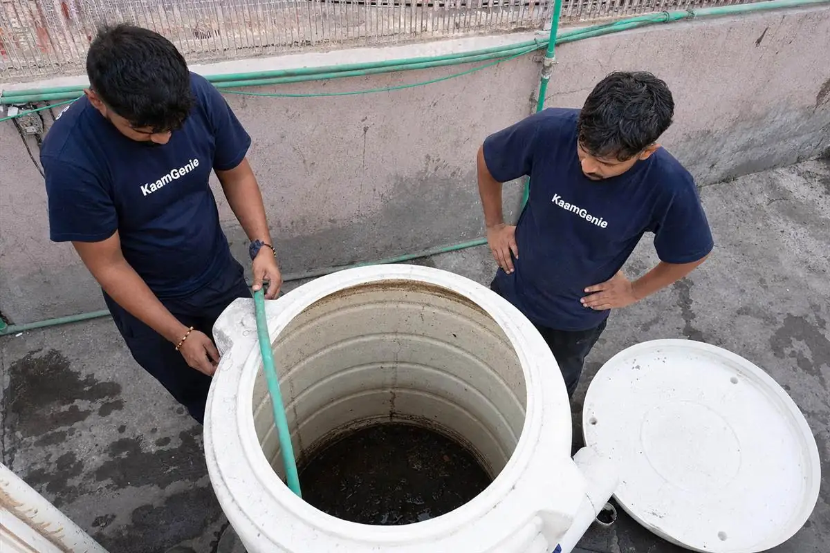 A Delhi rooftop tank only rinsed on top with a thick layer of dark sludge still sitting at the bottom