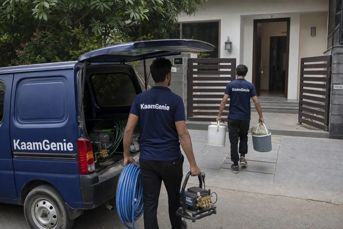 A navy KaamGenie van and two crew members arriving at a Gurgaon home for same-day water tank cleaning