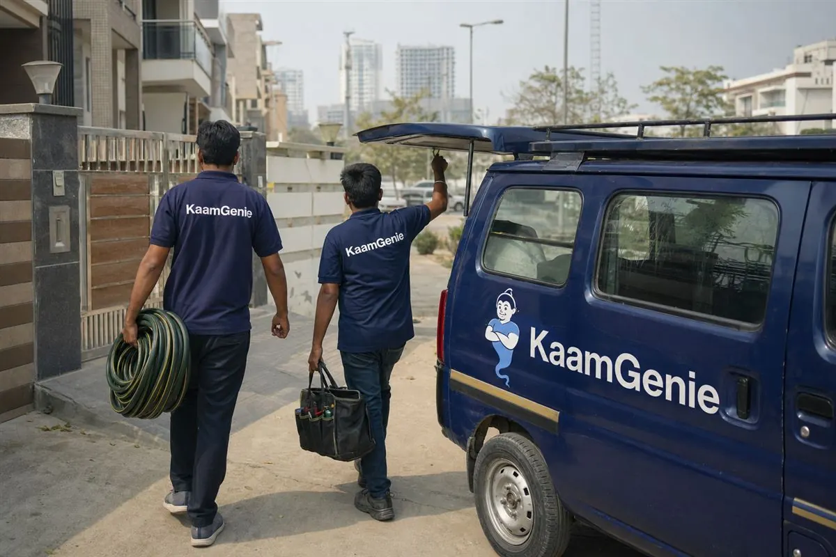A navy KaamGenie van and two crew members in navy shirts arriving at a Noida home for same-day water tank cleaning