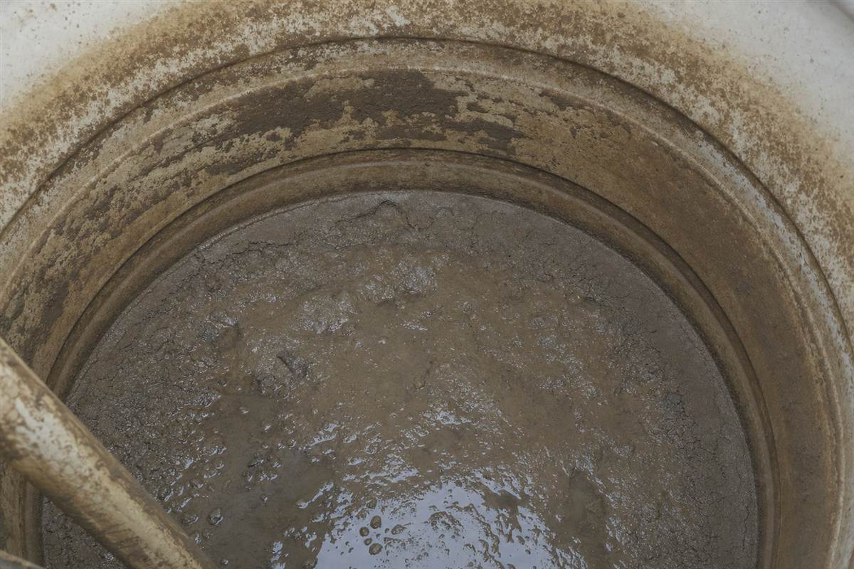 Close-up of dirty sediment and biofilm inside a Noida storage tank that feeds the whole home