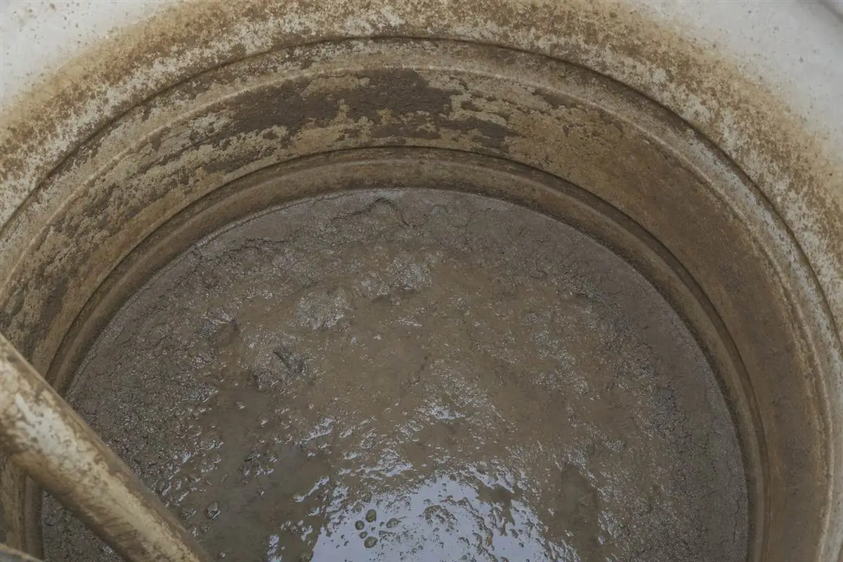 Close-up of dirty sediment and biofilm inside a Noida storage tank that feeds the whole home