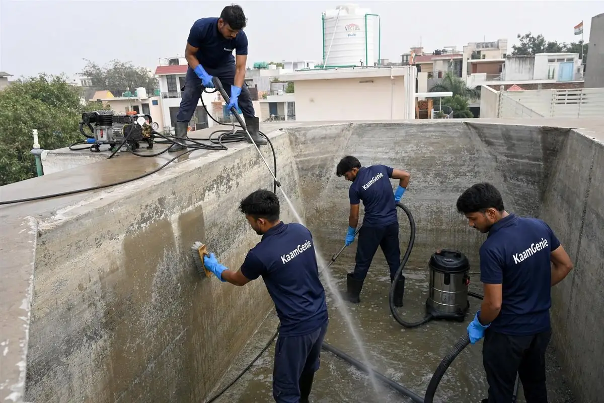 KaamGenie crew descaling white mineral crust from the walls of a borewell-fed water tank in South Delhi