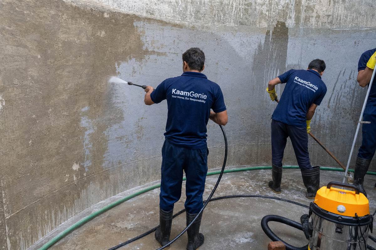 KaamGenie crew descaling white mineral crust from the walls of a borewell-fed water tank in South Delhi