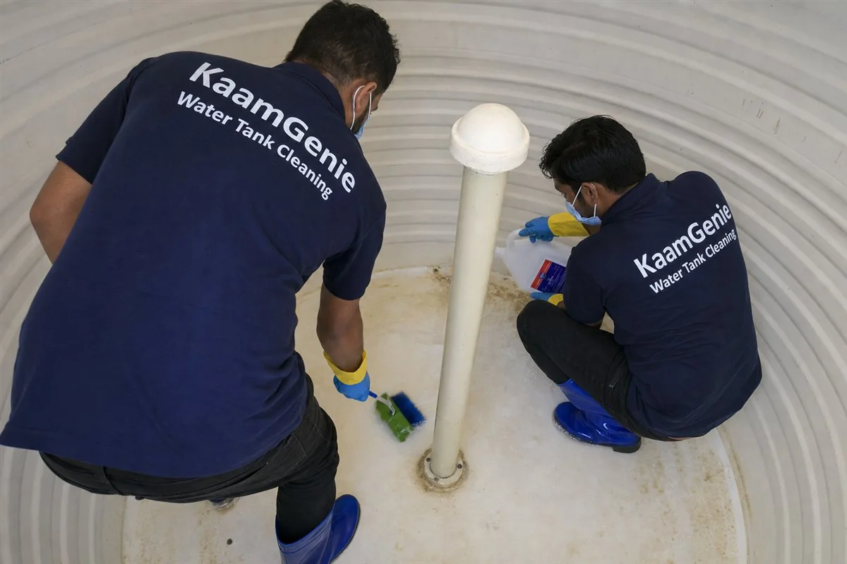 KaamGenie crew applying food-grade disinfectant solution inside a residential water tank in Delhi