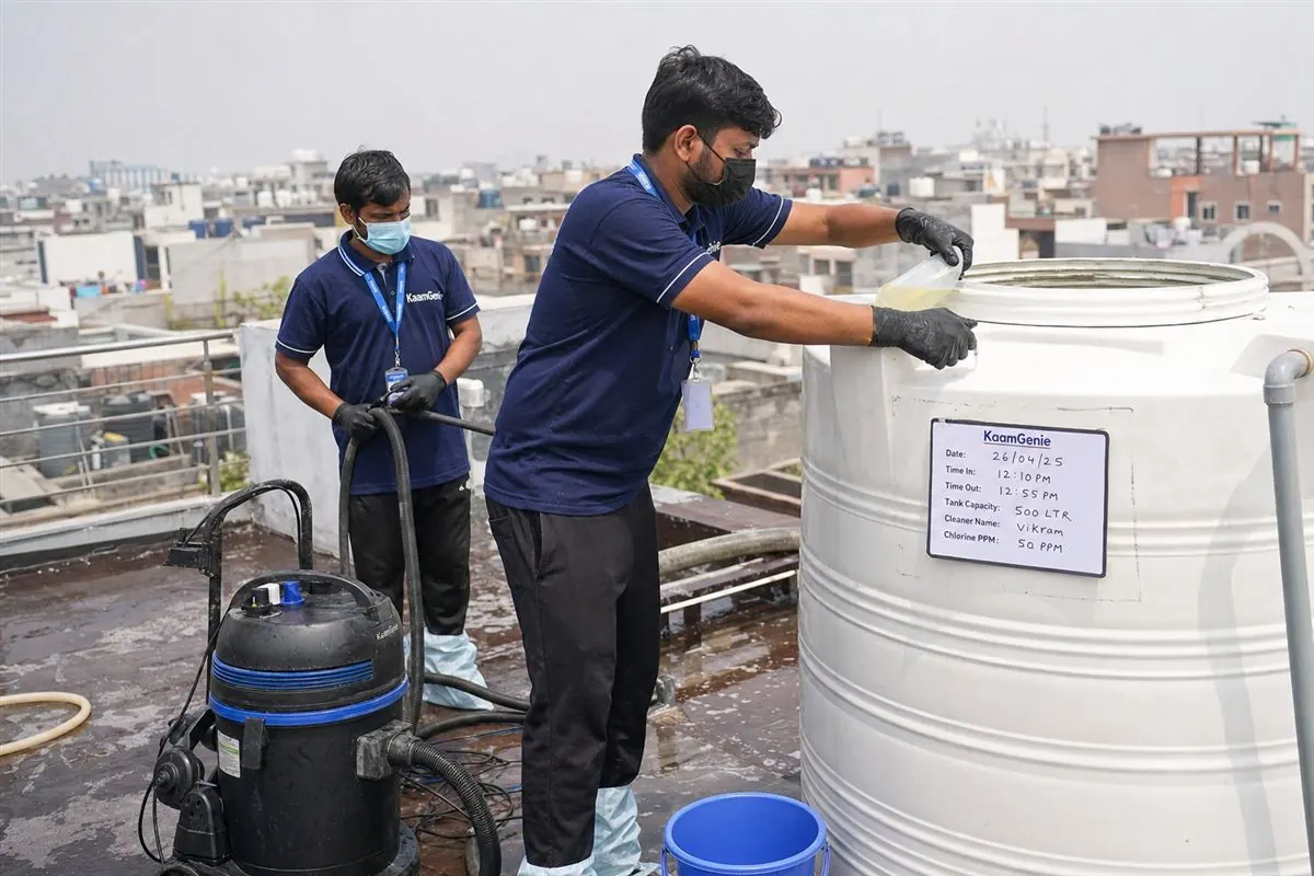KaamGenie crew applying food-grade disinfectant solution inside a residential water tank in Delhi