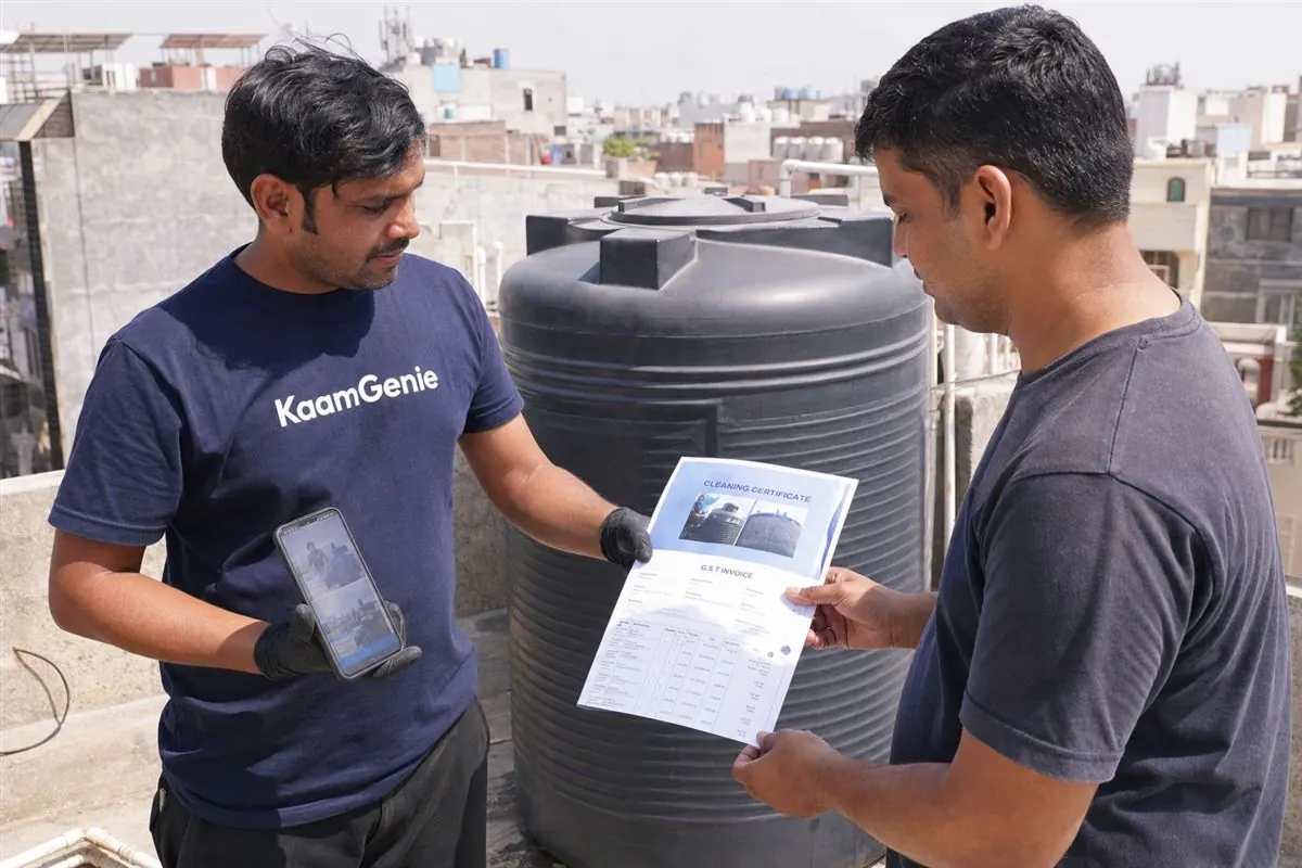 KaamGenie crew descaling a heavily neglected underground sump in Delhi using confined-space safety gear - an example of a paid add-on beyond the standard service